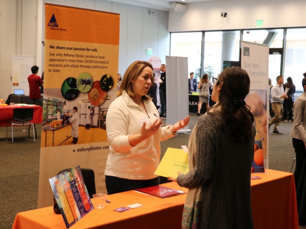 People talking at a booth at BBIE 2019