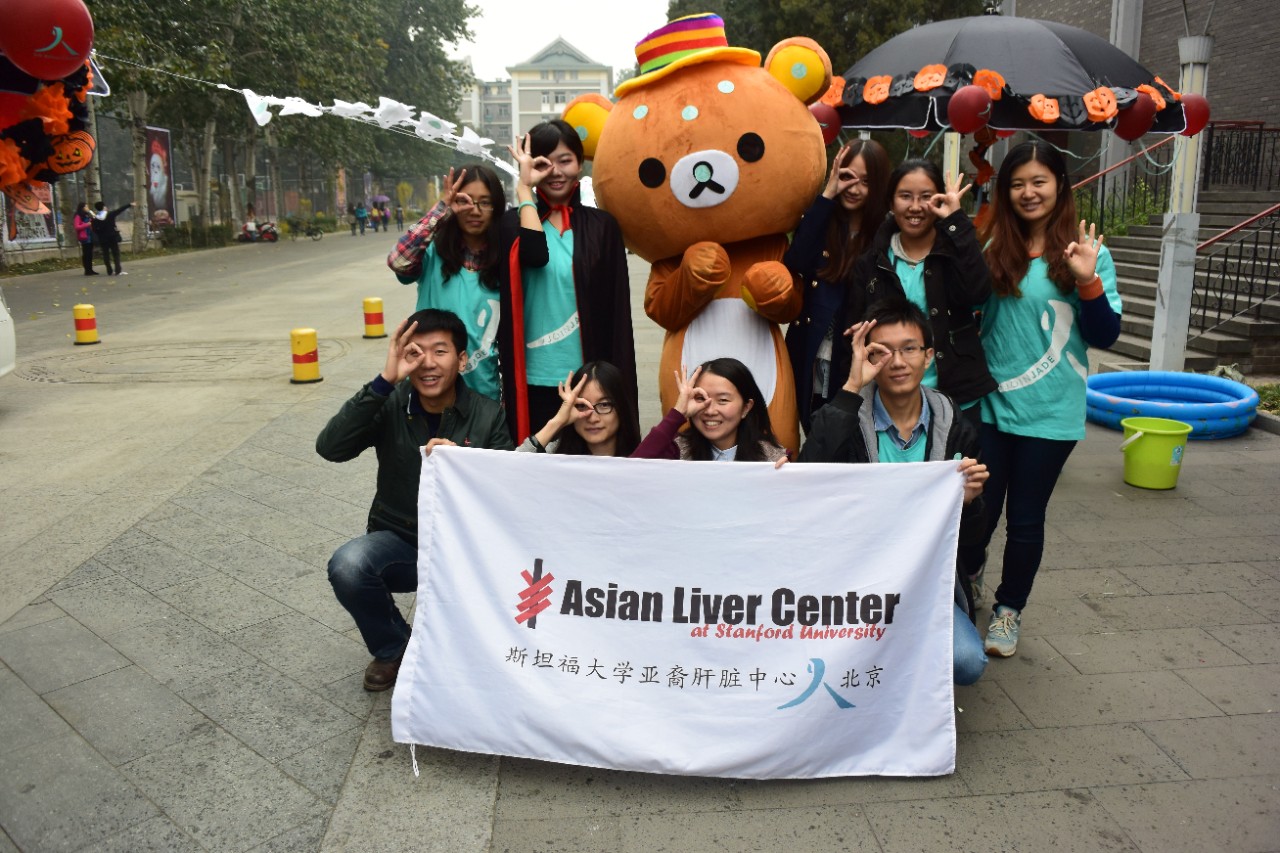 Group of people holding up Asian Liver Center outdoors