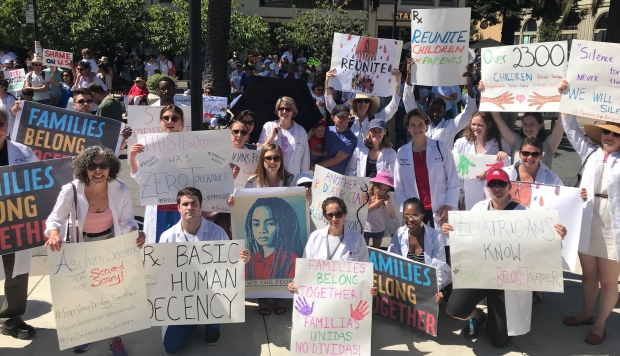 Physians with signs advocating for immigrant children