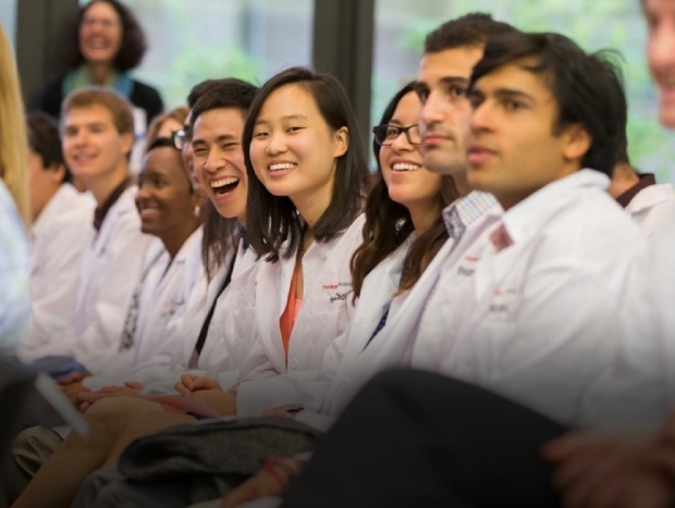 Students in white lab coats laughing 
