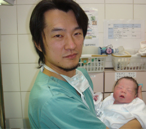 Kazuhiro Kawamura holding an infant
