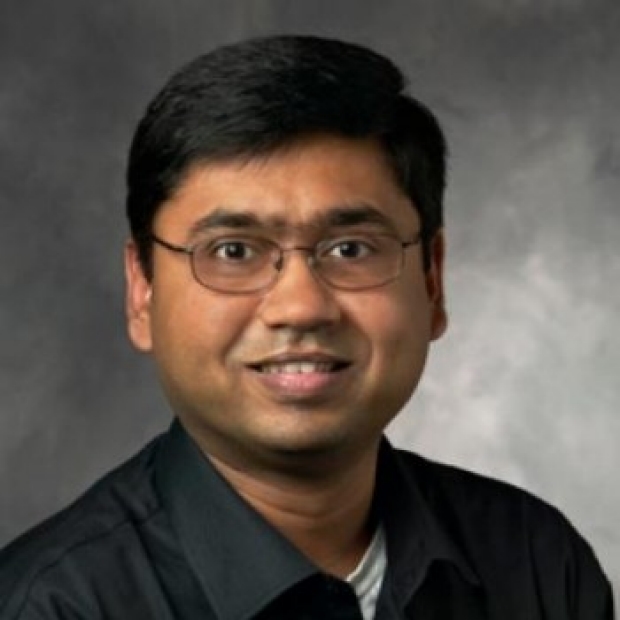 Image of Nigam H. Shah wearing a black button-up shirt in front of a grey background
