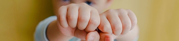 Toddler holding two fists together