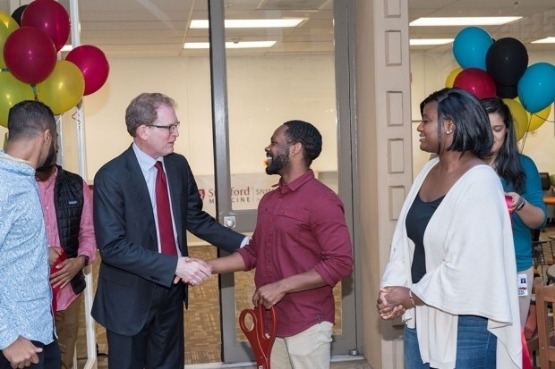 Dean Lloyd Minor shakes hands with Tawaun Lucas at the Oct. 2 opening of the medical school