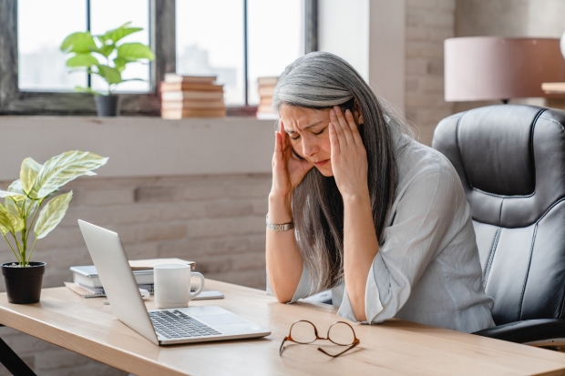 Woman at computer with glasses and migraine headache