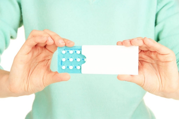 Woman's hands holding packet of pills