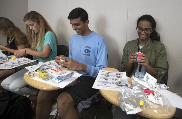 Four students making brain models out of clay