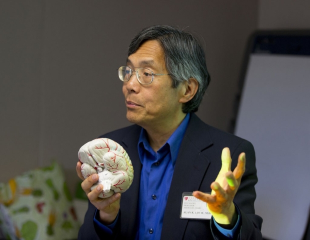 Alan Louie holding a model of a brain