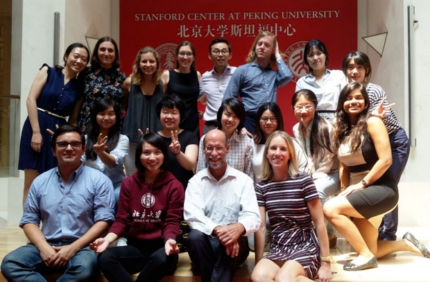 Faculty and students in front of a banner for Stanford Center at Peking University