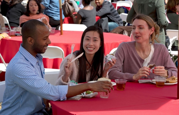 Man and two women seated at a table during a staff barbecue