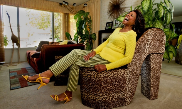 Woman laughing as she sits on a shoe-shaped chair