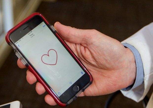 Hand holding a smartphone displaying the MyHeart Counts app