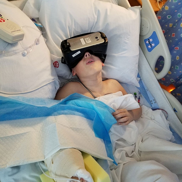 Child lying in a hospital bed, wearing virtual-reality goggles