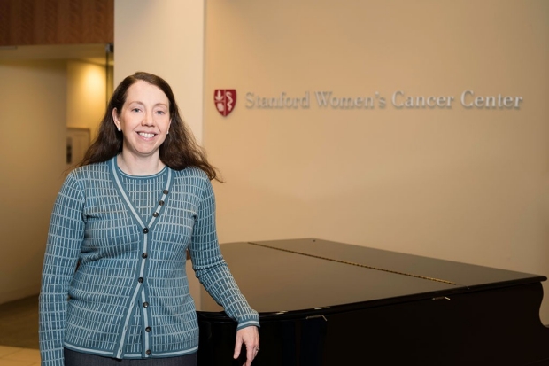 Woman standing in front of a desk at the Stanford Women's Cancer Center
