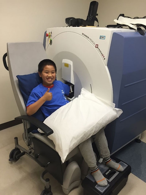 Boy getting his armed scan in a CT scanner