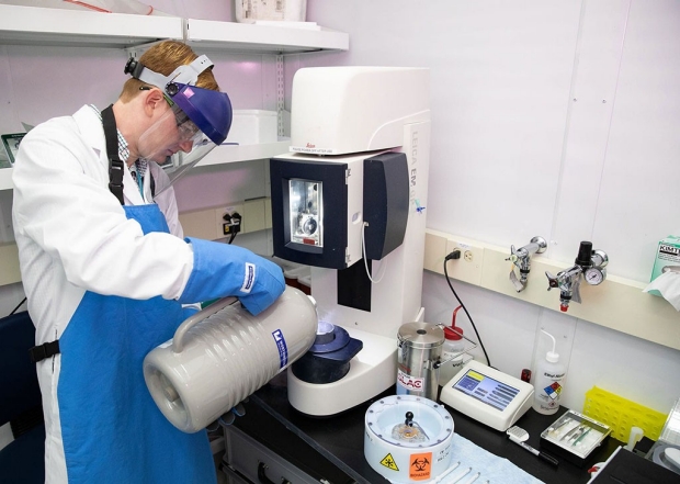 A graduate student pours liquid nitrogen into a cryo-EM device