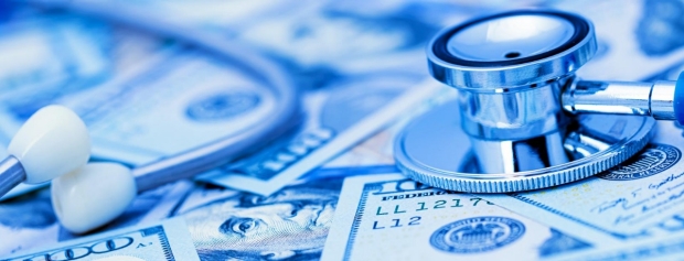 Stethoscope on the top of dollar bills in blue