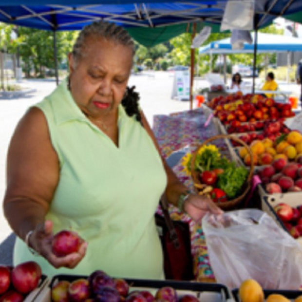 Woman picking fruit at a market