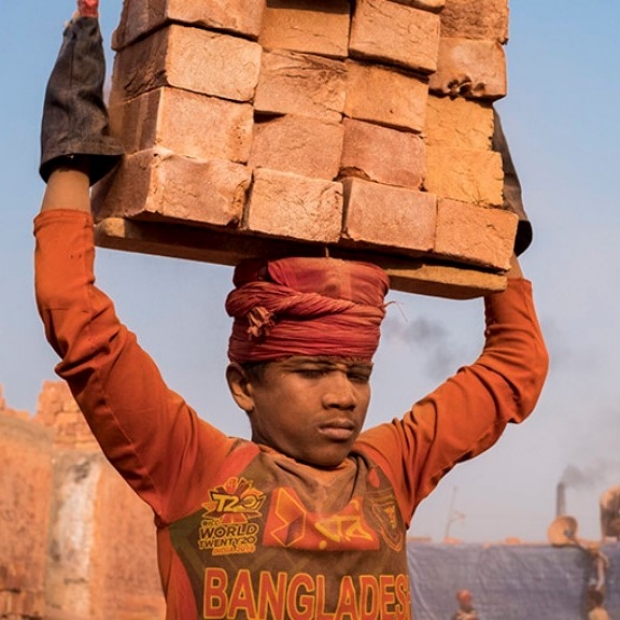 boy carrying bricks