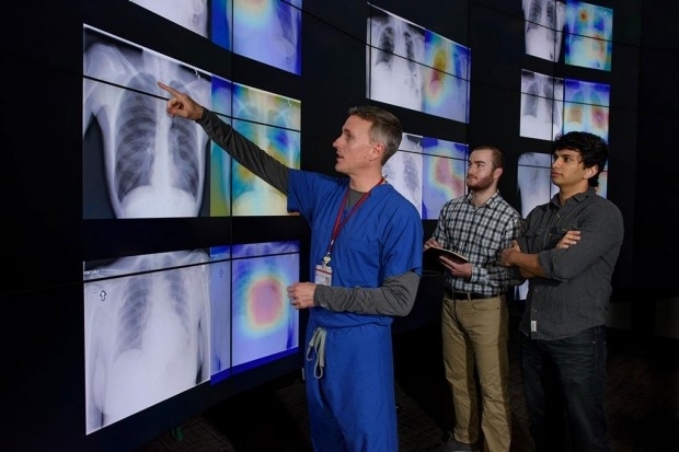 Photo of Matthew Lungren, left, and graduate students, Jeremy Irvin and Pranav Rajpurkar, discuss the results of detections made by the algorithm.