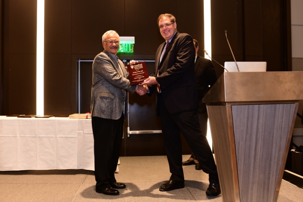 Photo of Norbert Pelc receiving 2019 Basic Scientist of the Year award from Garry Gold