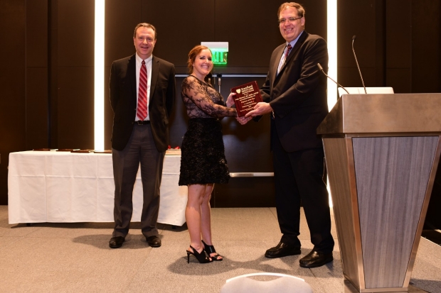 Photo of David Larson, Amy Macke receiving 2019 IR Employee of the Year award from Garry Gold