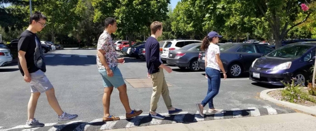 four people walking across street