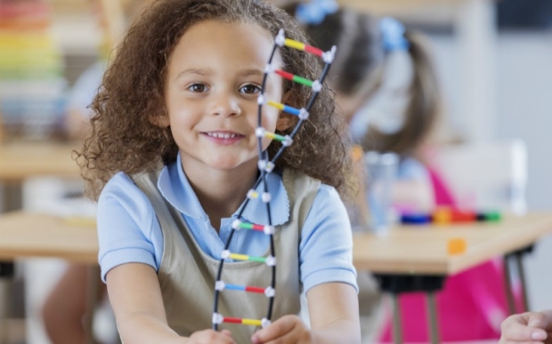 Young girl with plastic DNA strand toy