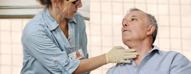 A doctor seeing a patient examining his neck
